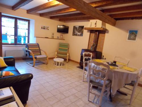 un salon avec une table et des chaises dans l'établissement gîte enso des Paoulìn, à Ustou