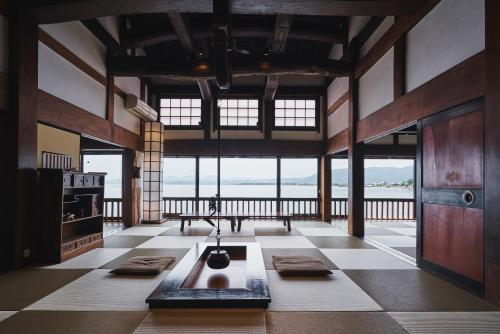 a large room with a table and some windows at 奥琵琶湖　四季亭 in Kaizu