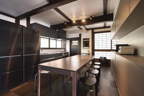 奥琵琶湖　四季亭 في Kaizu: مطبخ مع طاولة خشبية وبعض الكراسي