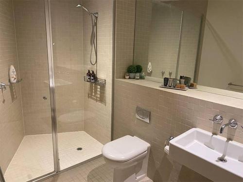 uma casa de banho com um chuveiro, um WC e um lavatório. em Superb City Views - Apartment, work or just relax! em Melbourne
