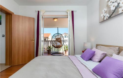 a bedroom with a bed with purple pillows and a balcony at 3 Bedroom Cozy Home In Loborika in Loborika