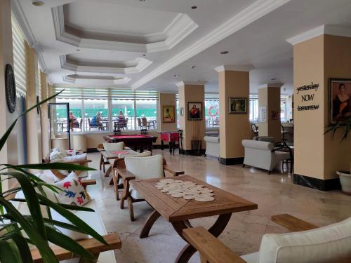 a living room with tables and chairs and a view of the ocean at Altinersan Hotel in Didim
