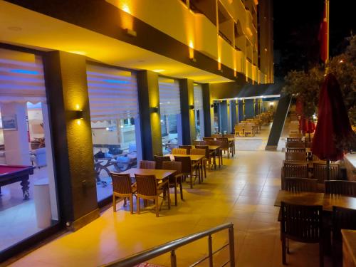 a row of tables and chairs in a restaurant at Altinersan Hotel in Didim