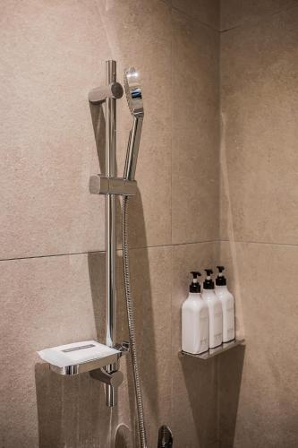 a shower in a bathroom with three bottles of soap at Aank Hotel Incheon Guwol in Incheon