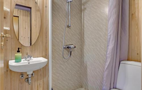 een badkamer met een wastafel, een toilet en een spiegel bij Lovely Home In Frvang With Wifi in Fårvang