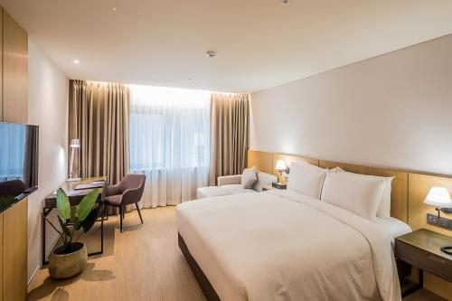 a hotel room with a large bed and a television at Aank Hotel Incheon Guwol in Incheon