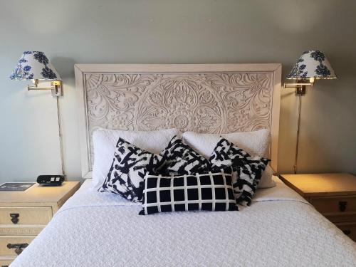 a bed with black and white pillows on it at THE NEW STAR MOTEL - 1950s Extended-Stay Lodging and Retreat Center in Moreno Valley