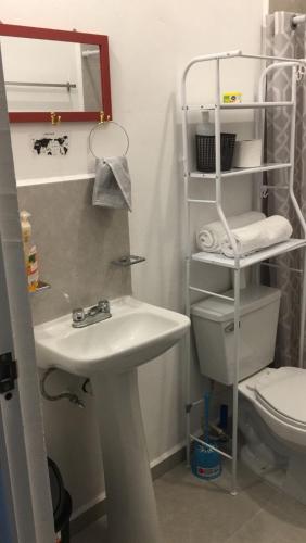 a bathroom with a white sink and a toilet at Casa Vacacional Maya Comitan in Comitán
