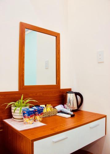 a wooden dresser with a mirror on top of it at Phuc Con Son Hotel in Con Dao