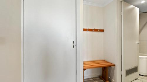 a small closet with a wooden bench in it at White Crystal 112 in Mount Hotham