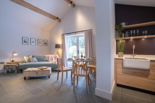 a kitchen and living room with a couch and a table at The Coach House - Lyth Valley by LetMeStay in Kendal
