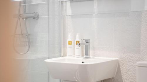 y baño blanco con lavabo y ducha. en Bronte Apartment - Dales - Lakes - Kirkby Lonsdale en Carnforth