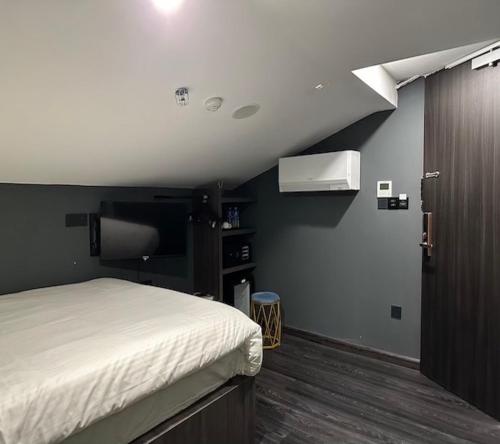 a bedroom with a bed and a tv in a room at HOTEL JJH - newly opened near BUGIS in Singapore