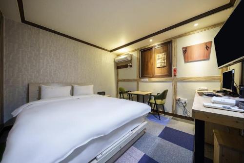浦項的住宿－Subiztel，酒店客房设有一张大床和一张书桌。