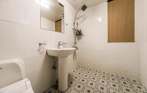 a white bathroom with a sink and a mirror at Subiztel in Pohang