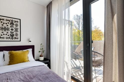 Schlafzimmer mit einem Bett neben einer Glasschiebetür in der Unterkunft Cosy Home Paupys in Vilnius