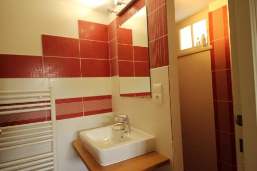 a bathroom with a sink and red and white tiles at Henriette, villa de charme entre plage et marché in La Brée-les-Bains
