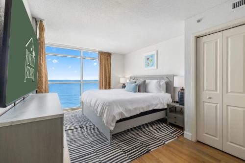 a bedroom with a bed and a view of the ocean at The Grand Myrtle BAY VIEW 1503 Full New Remodel in Myrtle Beach