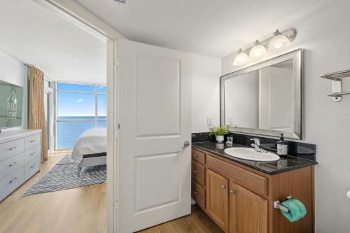 un bagno con lavandino, specchio e letto di The Grand Myrtle BAY VIEW 1503 Full New Remodel a Myrtle Beach