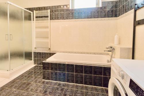 een badkamer met een bad, een wastafel en een douche bij Svůj vlastní soukromý ráj-nájem apartmánu v Berouně! in Beroun