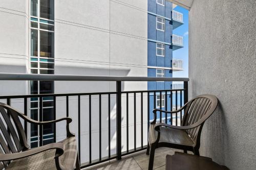 two chairs on a balcony with a view of a building at The Grand Myrtle BAY VIEW 1503 Full New Remodel in Myrtle Beach