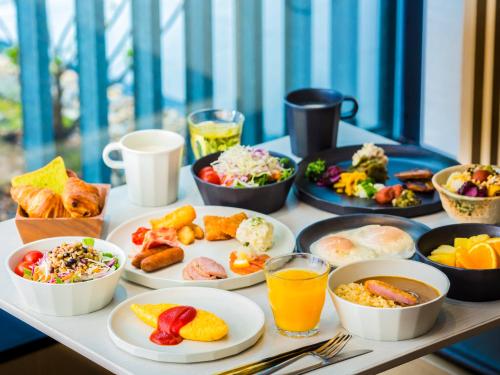 a table topped with plates of food and drinks at Hyatt Place Kyoto in Kyoto