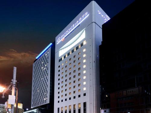 a lit up building in a city at night at Daiwa Roynet Hotel Nagoya Shinkansenguchi in Nagoya