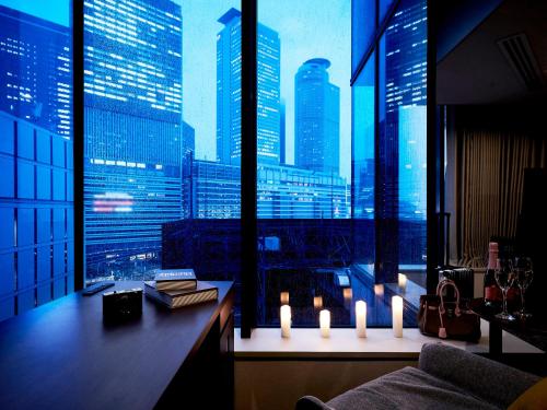 a room with a view of a city skyline with candles at Daiwa Roynet Hotel Nagoya Shinkansenguchi in Nagoya