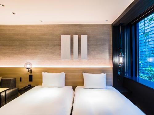 two beds in a room with a window at Hyatt Place Kyoto in Kyoto