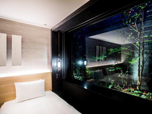 a bedroom with a large window with a fish tank at Hyatt Place Kyoto in Kyoto