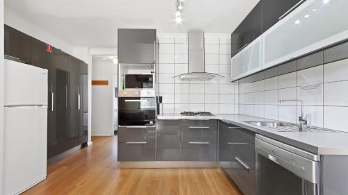 a large kitchen with stainless steel appliances and wood floors at Alpine Haven 5 in Mount Hotham