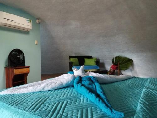 sypialnia z łóżkiem z niebieską kołdrą z rozgwiazdą w obiekcie Domito Corcovado w mieście Bahía Drake