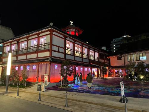 a large building with people standing in front of it at night at パインツリー in Matsuyama