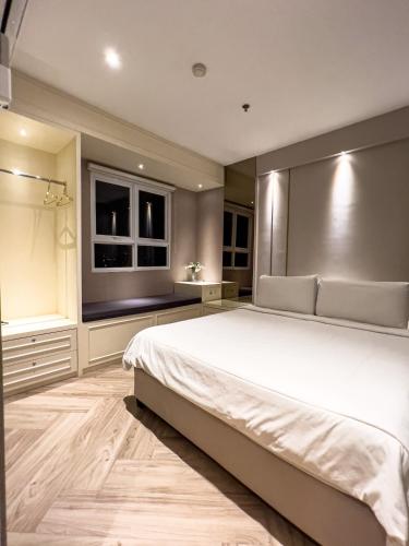 a bedroom with a large white bed and two windows at R30 Apartemen Gateway Pasteur 2BR Daymentroom in Bandung