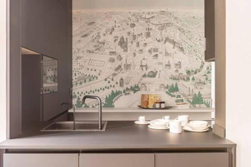 eine Küche mit einem Waschbecken und einem Wandbild in der Unterkunft ECOZYHOUSE in Florenz