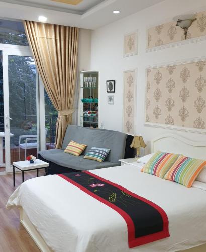 a bedroom with a large bed and a couch at CHEZ LOTUS VN in Ho Chi Minh City