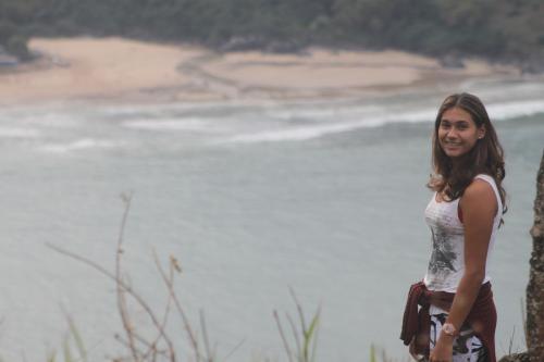 a woman standing next to a body of water at Pousada da Rosa in Ilhabela