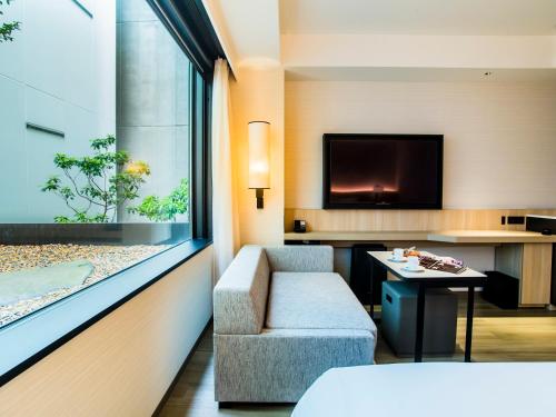 a hotel room with a couch and a fish tank at Hyatt Place Kyoto in Kyoto