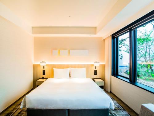 a bedroom with a bed and a large window at Hyatt Place Kyoto in Kyoto
