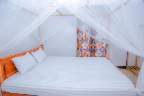 a bedroom with a white bed with a canopy at purple villa in Mirissa