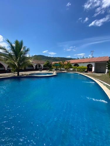 a large blue swimming pool with a palm tree at Hacienda La Pola in Guaduas