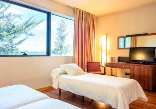a hotel room with two beds and a large window at Hotel Restaurante El Valles 4 ESTRELLAS in Briviesca