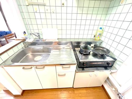 uma pequena cozinha com um lavatório e um fogão em Avidasion - Vacation STAY 12208 em Biei