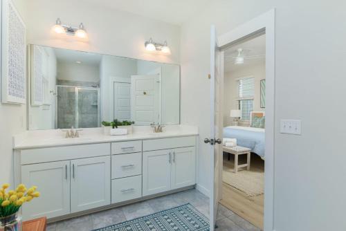 La salle de bains blanche est pourvue d'un lavabo et d'un miroir. dans l'établissement Happy Ours Mins to Park Circle Dtwn CHS Beach, à Charleston