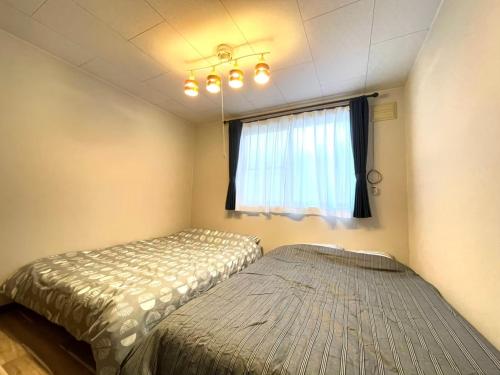um quarto com uma cama e uma janela em Avidasion - Vacation STAY 12209 em Biei