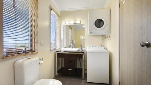 a bathroom with a toilet and a sink and a microwave at Breck in Dinner Plain