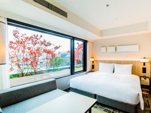 a hotel room with a bed and a large window at Hyatt Place Kyoto in Kyoto