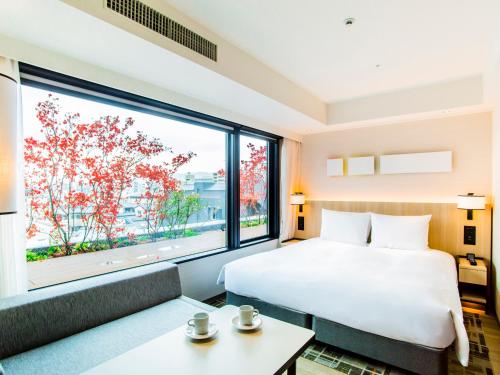 a hotel room with a bed and a large window at Hyatt Place Kyoto in Kyoto