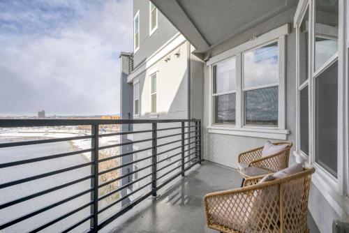 a balcony with a wicker chair and windows at Designer Apt w Jacuzzi Walk To Casino & iMax in Sparks