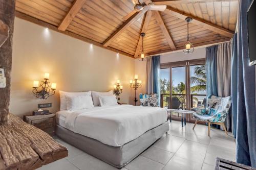 sypialnia z dużym łóżkiem i dużym oknem w obiekcie The Baga Beach Resort w mieście Baga